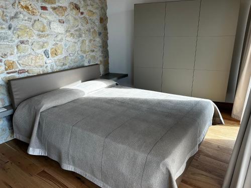 a bed in a bedroom with a stone wall at Nuovo B&B Colline San Benedetto in Marostica