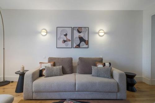 - un salon avec un canapé et deux photos sur le mur dans l'établissement AmazingApartment #GalleriesLafayette #Madeleine#AC, à Paris