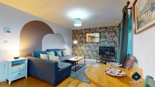 a living room with a blue couch and a table at *Cosy Annexe in Forest of Dean* in Coleford