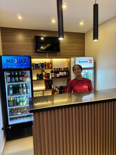 a man standing at a bar with a refrigerator at MITOS LUXURY SUITES (BODE THOMAS) in Lagos