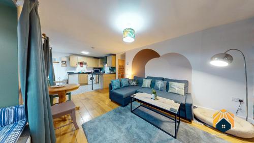 uma sala de estar com um sofá azul e uma mesa em *Cosy Annexe in Forest of Dean* em Coleford