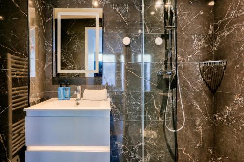 une salle de bain avec un lavabo et une douche dans l'établissement Urban Flat 129 - Art Love Champs-Elysees, à Paris