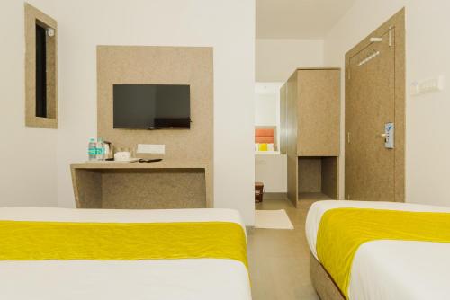 a hotel room with two beds and a tv at Hotel Zillion Executive Near US Consulate Bandra Kurla Complex Mumbai Near Mumbai Airport Mumbai in Mumbai