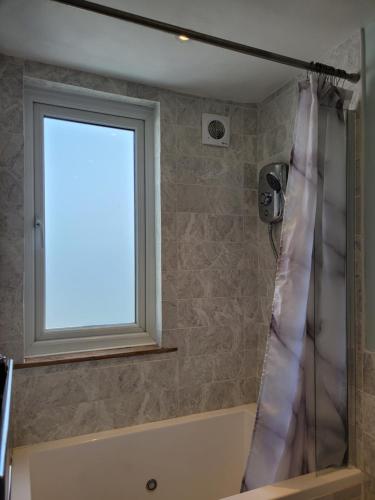 a shower curtain in a bathroom with a window at LITTLE HAVEN 1 Bedroom House sought after area in Topsham