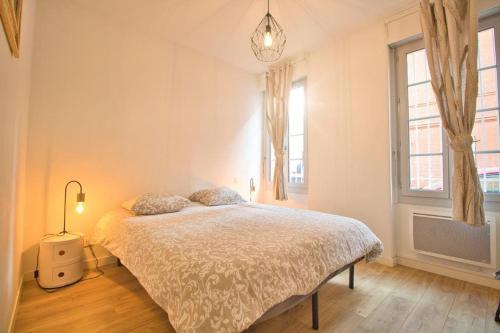 um quarto com uma cama e duas janelas em *T2*Terrasse*Calme*Centre-Ville*Gare*Commerce* em Toulouse