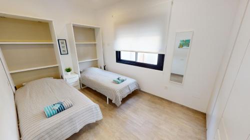 Cette petite chambre comprend 2 lits et une fenêtre. dans l'établissement Punto Residences "Villa Deluxe", à Los Alcázares