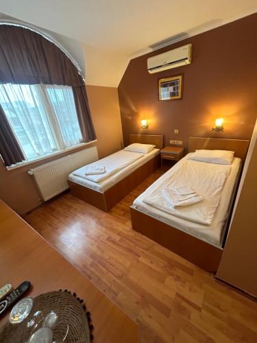a small room with two beds and a window at Capone in Satu Mare