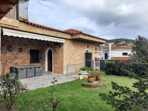 a house with a patio and a yard with a yard at Marathon VS LUXURY VILLA in Grammatiko