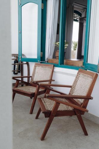 a pair of chairs sitting in front of a mirror at Lighthouse Ahangama in Ahangama