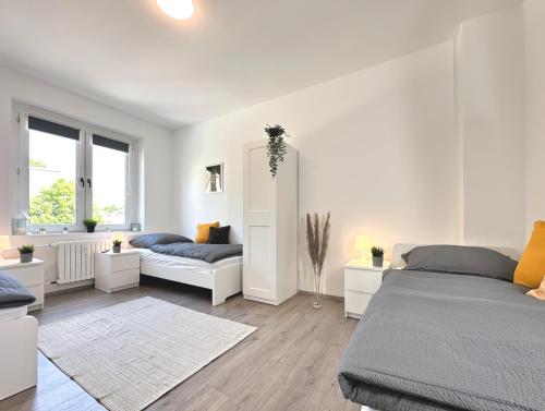 a white bedroom with two beds and a window at Monteurwohnung mit Balkon in Hattingen