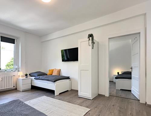 a white room with two beds and a mirror at Monteurwohnung mit Balkon in Hattingen