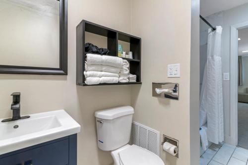 a bathroom with a toilet and a sink and a mirror at Downtown Dover Inn in Dover