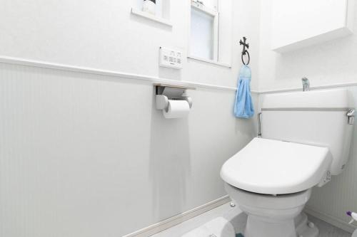 a white bathroom with a toilet and a window at Kishisato Japanese House QB-1 in Osaka
