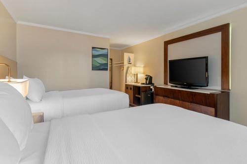 a hotel room with two beds and a flat screen tv at Downtown Dover Inn in Dover