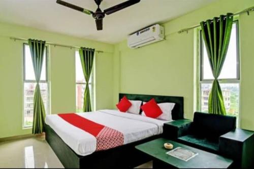 1 dormitorio con 1 cama con almohadas rojas en Goroomgo Green Oasis Inn Kolkata, en Pānchuria
