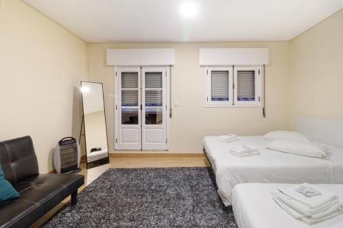 sala de estar con 2 camas y sofá en Apartamento Vi-ana, en Viana do Castelo