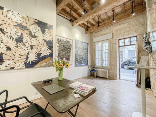 - un salon avec une table et des fleurs sur le mur dans l'établissement Studio 26*Galerie*Commerce*Arles centre, à Arles