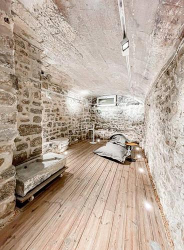 une chambre avec un lit et un mur en pierre dans l'établissement Studio 26*Galerie*Commerce*Arles centre, à Arles