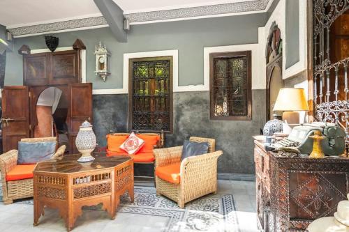a living room with orange chairs and a table at Riad des Mile Nuits in Marrakesh