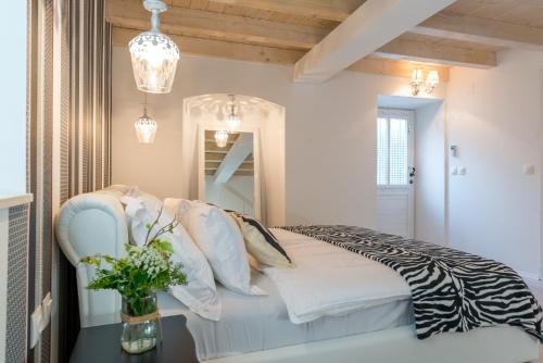 Un dormitorio con una cama con un jarrón de flores en Apartments La Bohème, en Dubrovnik