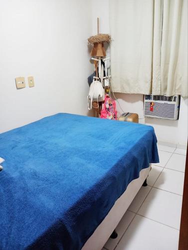 um quarto com uma cama com um cobertor azul em Apê da Mel - Recife PE no Recife