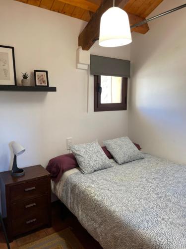 a bedroom with a bed and a lamp on a night stand at CASA DE LA BODEGA in Espluga de Francolí