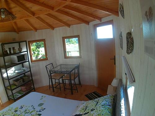 ValmontにあるCabane Perchée dans la prairie de l'ancien moulinのベッド1台とテーブルが備わる部屋