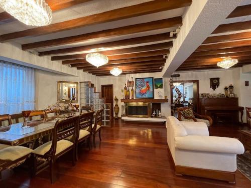 uma grande sala de estar com mesa e cadeiras em Casa hermosa, amplia y elegante em Quito