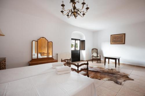 ein Esszimmer mit einem großen weißen Tisch und Stühlen in der Unterkunft Alojamiento El Monasterio in Almonaster la Real