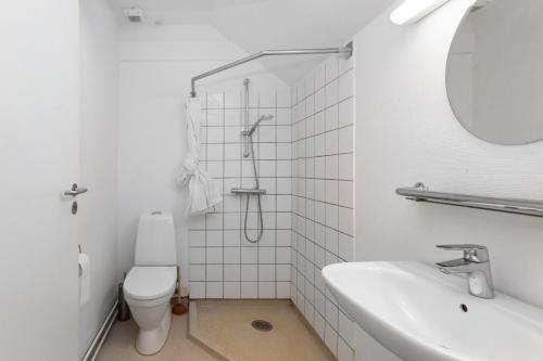 een witte badkamer met een toilet en een wastafel bij Centralt Byliv - 2 Soveværelser med plads til 6 in Aarhus