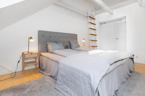 um quarto com uma cama grande num quarto branco em Centralt Byliv - 2 Soveværelser med plads til 6 em Aarhus