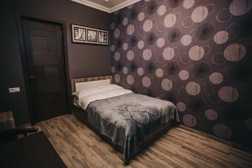 a bedroom with a bed and a wall with polka dots at 7 Rooms Hotel in Tserovani