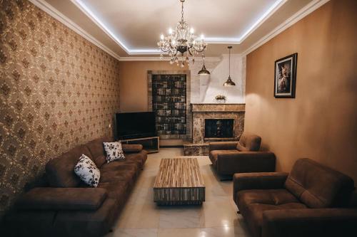 a living room with couches and a fireplace at 7 Rooms Hotel in Tserovani