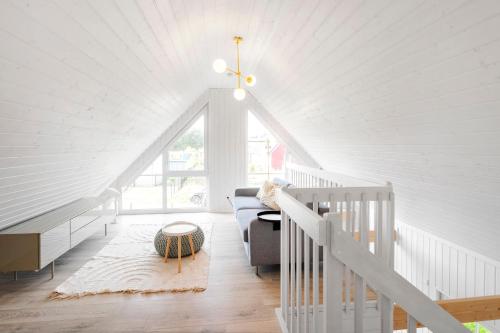 a white attic room with a white ceiling at Scandinavian Lifestyle-Ferienhaus in der Natur in Wandlitz