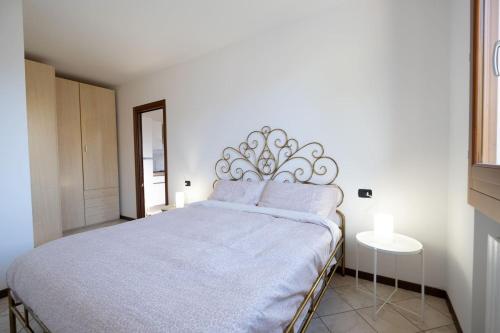 モンタニャーナにあるDimore Al Borgo 2の白いベッドルーム(紫色の枕を使用した大型ベッド1台付)
