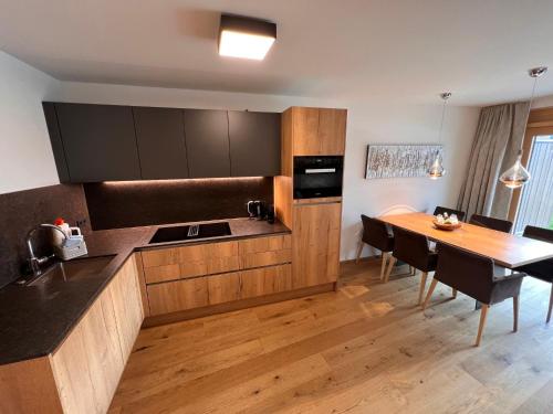 a kitchen with a table and a dining room at Apartment Lakeside Luxury Apartments by Interhome in Zell am See