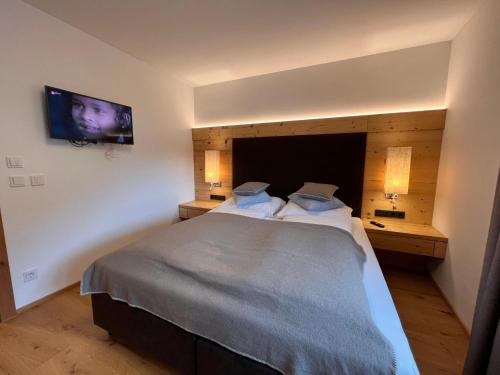 a bedroom with a large bed and a flat screen tv at Apartment Lakeside Luxury Apartments by Interhome in Zell am See