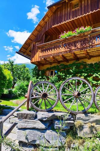 a wooden building with a wooden cart with flowers on it at Holiday Home st martin chalets-1 by Interhome in Sankt Martin
