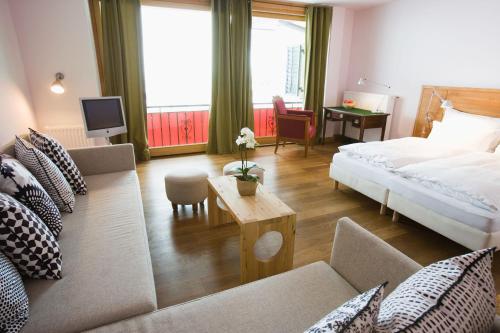 a hotel room with a bed and a living room at Alpine Spa Hotel Haus Hirt in Bad Gastein