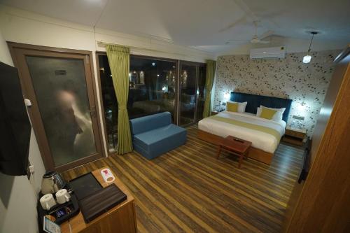 ein Hotelzimmer mit einem Bett und einem blauen Sofa in der Unterkunft SKD RESORT AND CLUB 