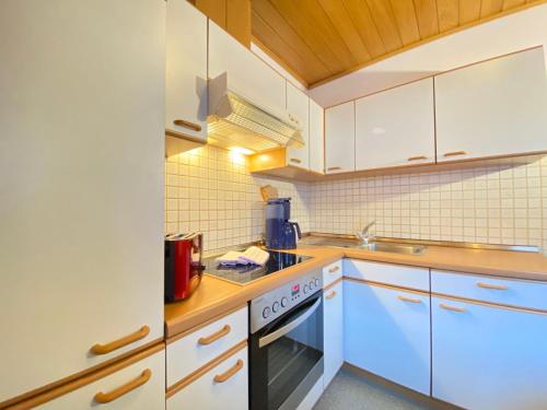 a kitchen with white cabinets and a stove top oven at Holiday Home IN8 - max- 7 Personen by Interhome in Saalbach-Hinterglemm