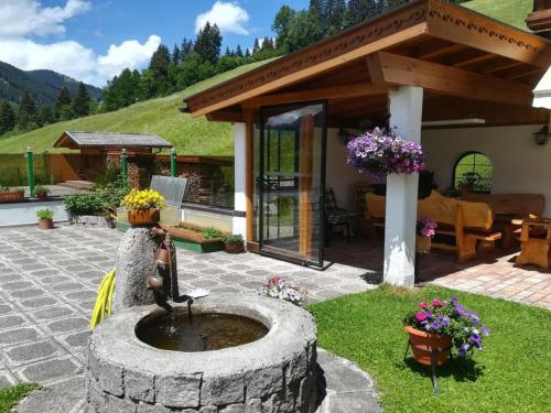a garden with a fountain in the middle of a patio at Holiday Home IN8 - max- 7 Personen by Interhome in Saalbach-Hinterglemm