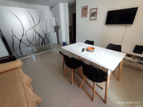 una mesa blanca y sillas en la sala de estar. en Departamentos Córdoba Vaes en Córdoba