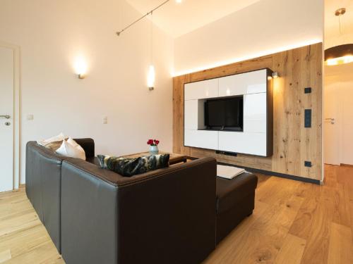 uma sala de estar com um sofá e uma televisão de ecrã plano em Apartment Christine Penthouse by Interhome em Eben im Pongau
