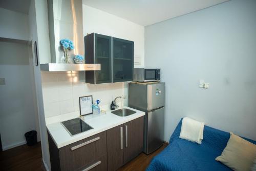 a small kitchen with a sink and a refrigerator at Studio with Netflix, 55in TV, 200Mbs net, in heart of Makati in Manila