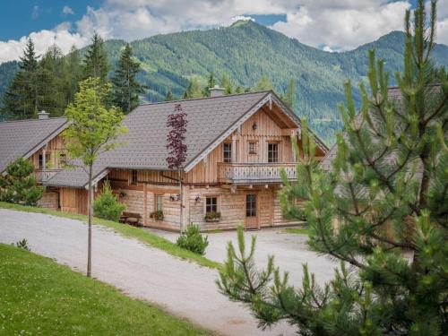 a large wooden house with mountains in the background at Holiday Home Premium Waldjuwel by Interhome in Pichl