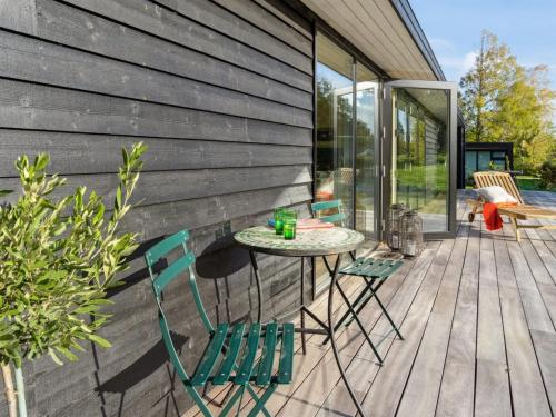 un patio con sillas y una mesa en una terraza en Holiday Home Tessa - 1-6km from the sea in Sealand by Interhome en Græsted