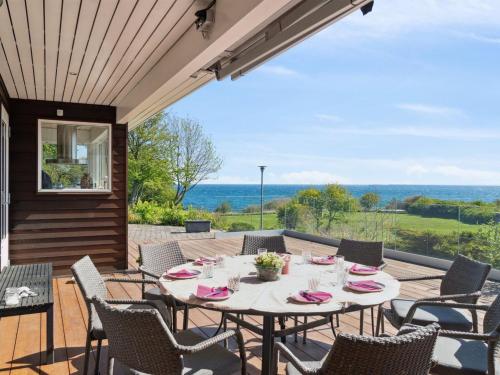 a table and chairs on a patio with a view of the ocean at Holiday Home Sahid - 20m from the sea by Interhome in Klint