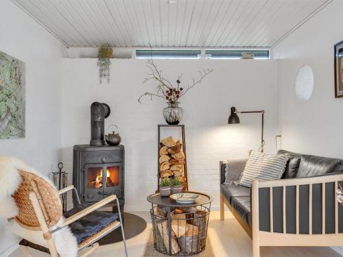 uma sala de estar com um sofá e um fogão a lenha em Holiday Home Elma - 350m from the sea in SE Jutland by Interhome em Juelsminde