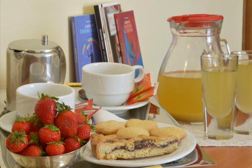 una mesa con un plato de comida y fresas y una bebida en Albergo Martini, en Chianciano Terme